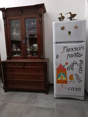 a dresser and a refrigerator next to a cabinet at Syd's House in Bagheria