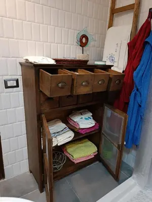a wooden shelf with folded towels in a bathroom at Syd's House in Bagheria