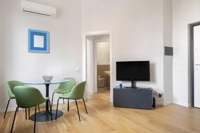 a living room with a table and chairs and a television at Ninni's House by DomuSicily in Palermo