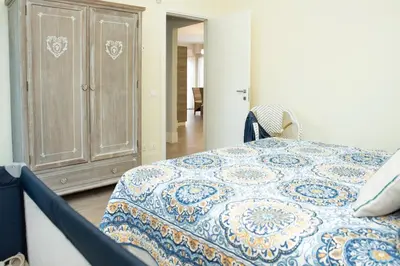 a bedroom with a blue and white bed and a cabinet at Villa Rosina in Cinisi