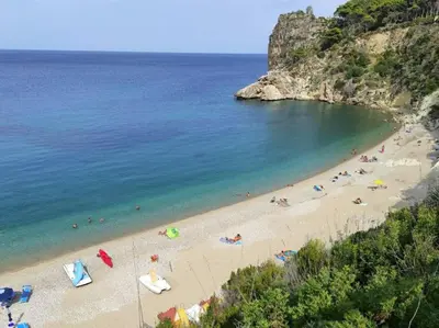a beach with a bunch of people in the water at Villa Corallo Sicily - Scopello Guidaloca Bay in Scopello
