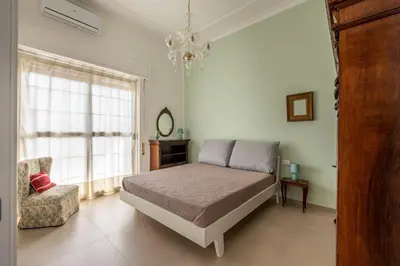 a bedroom with a bed and a chair and a window at Appartamento a due passi da Villa Trabia by Wonderful Italy in Palermo
