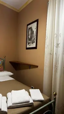 a bedroom with a bed and a window with towels at Laura Affittacamere in Palermo