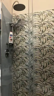 a shower with a glass door with a wallpaper at Laura Affittacamere in Palermo