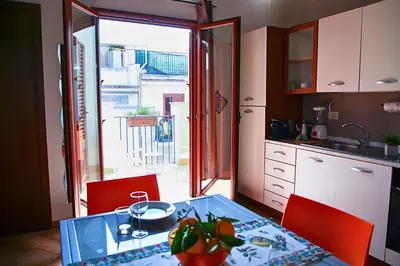 a kitchen with a glass table and red chairs at Cattedrale - VISTA HOUSE easy parking in Palermo