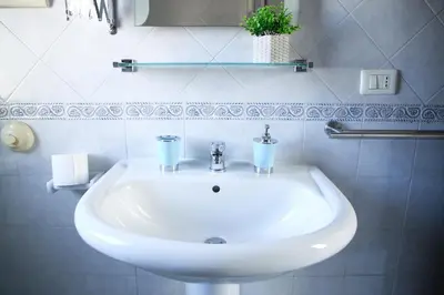 a bathroom sink with two cups on top of it at Cattedrale - VISTA HOUSE easy parking in Palermo