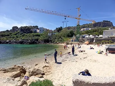 a group of people on a beach with a crane at La Casetta di Marianne in Santa Flavia