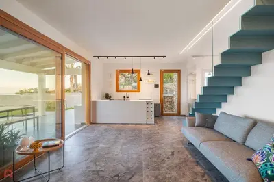a living room with a blue couch and a staircase at Sea View Villa whit Pool in Scopello