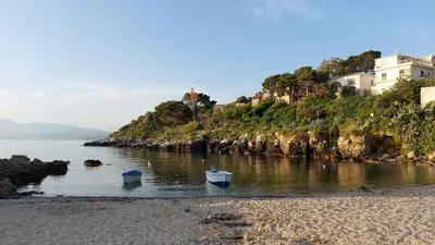 two boats in the water next to a beach at Casa Lo Re in Santa Flavia