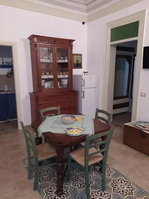 a kitchen with a table and chairs and a refrigerator at Casa Lo Re in Santa Flavia