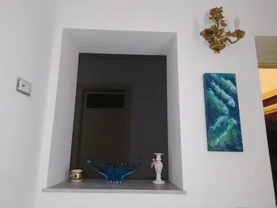 a room with a blue vase and a painting at Casa Lo Re in Santa Flavia