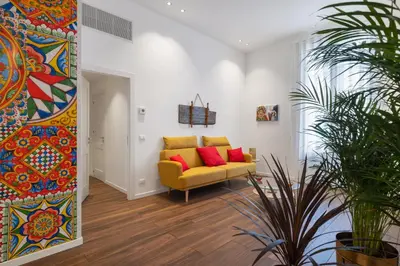 a living room with a yellow couch and red pillows at Casa Brezi in Palermo
