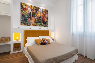 a bedroom with a bed with a painting on the wall at Casa Brezi in Palermo