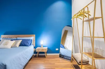 a bedroom with blue walls and a bed with a ladder at Casa Brezi in Palermo