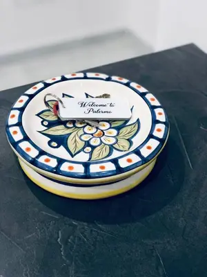 a plate with a flower pattern on it sitting on a table at Casa vacanze Rigano Palermo in Palermo