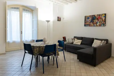 a living room with a table and a couch at Dimora Artale in Cattedrale in Palermo