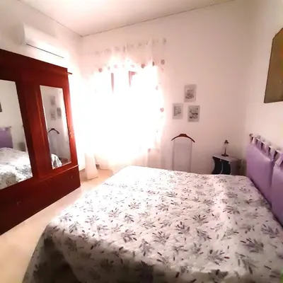 a bedroom with a bed and a large window at La comodità a due passi dal mare di Mondello in Mondello