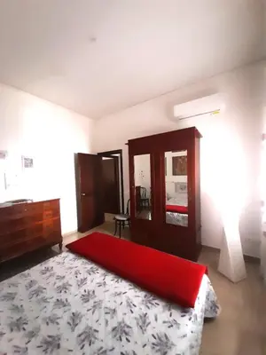 a bedroom with a red bed and a mirror at La comodità a due passi dal mare di Mondello in Mondello