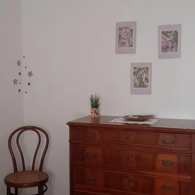 a wooden dresser and a chair in a room at La comodità a due passi dal mare di Mondello in Mondello