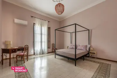 a bedroom with a canopy bed and a desk at Stylish apartment near Piazza Magione by Wonderful Italy in Palermo