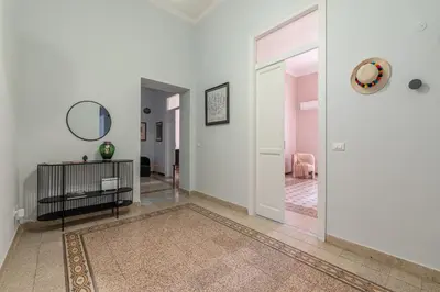 a hallway with white walls and a door with a mirror at Stylish apartment near Piazza Magione by Wonderful Italy in Palermo