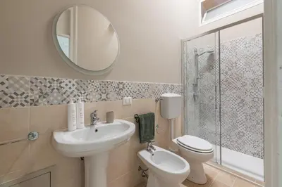 a bathroom with a sink and a toilet and a mirror at Stylish apartment near Piazza Magione by Wonderful Italy in Palermo