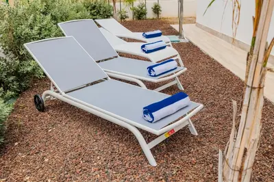 four lounge chairs lined up on a patio at Villa delle Palme in Campofelice di Roccella
