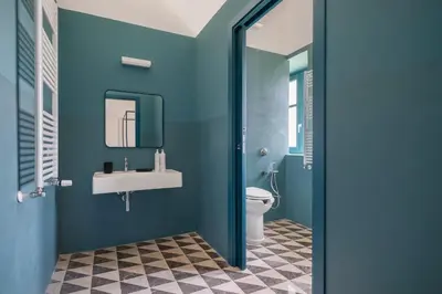 a blue bathroom with a sink and a toilet at Casa San Francesco Rooms in Palermo