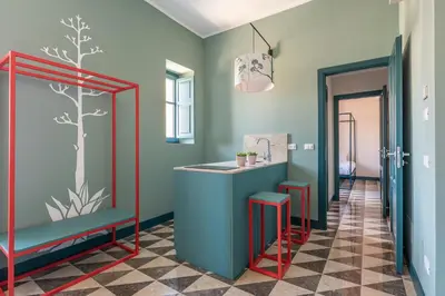 a kitchen with green walls and a blue counter with stools at Casa San Francesco Rooms in Palermo
