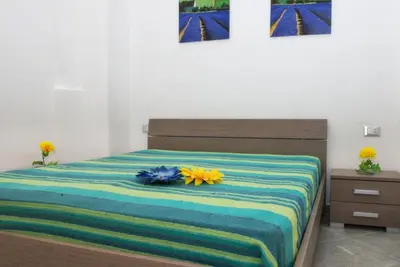 a bedroom with a bed with flowers on it at Casa Longo 2 in Castellammare del Golfo
