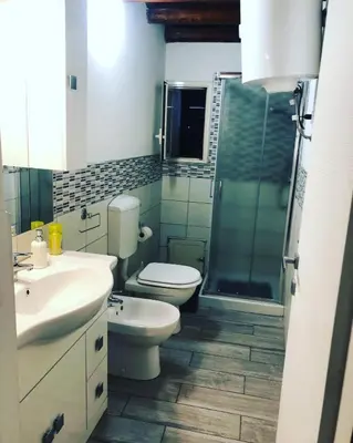 a bathroom with a toilet and a sink and a shower at La casetta del borgo in Palermo