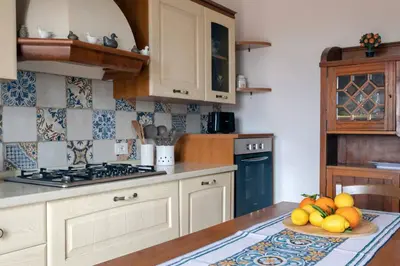a kitchen with a bowl of fruit on a table at Villa Marina Sant'Elia in Santa Flavia