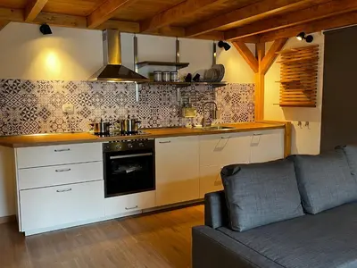 a kitchen with a stove top oven next to a couch at A casa del Conte in Palermo