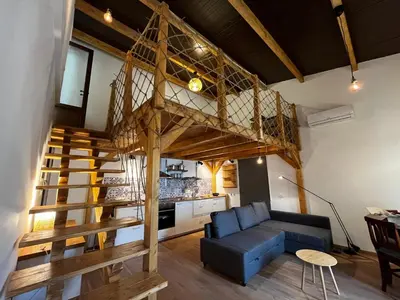 a loft apartment with a staircase and a blue couch at A casa del Conte in Palermo