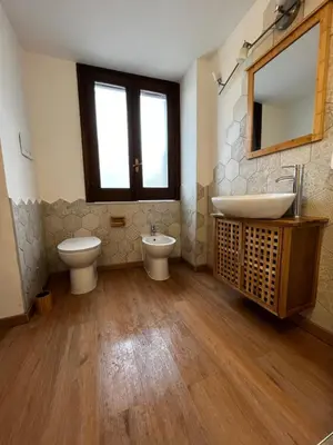 a bathroom with two toilets and a sink and a mirror at A casa del Conte in Palermo