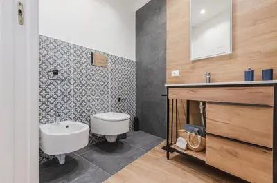 a bathroom with a white sink and a toilet at GuestHost - Ballarò Cozy Apartment with Balconies in Palermo