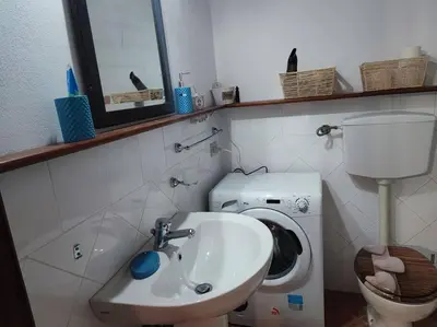 a bathroom with a sink and a toilet and a mirror at Palermo Al Capo in Palermo
