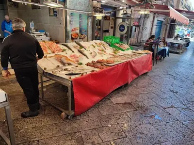 a man standing in front of a table full of seafood at Palermo Al Capo in Palermo