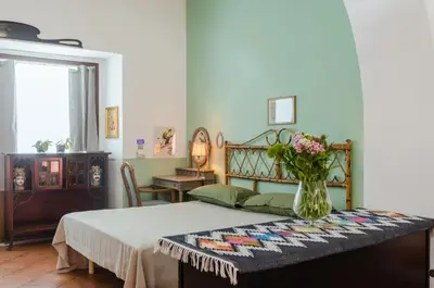 a bedroom with a bed with a vase of flowers at GuestHost - Teatro Politeama Functional Studio x4 in Palermo