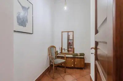 a hallway with a chair and a mirror at GuestHost - Teatro Politeama Functional Studio x4 in Palermo