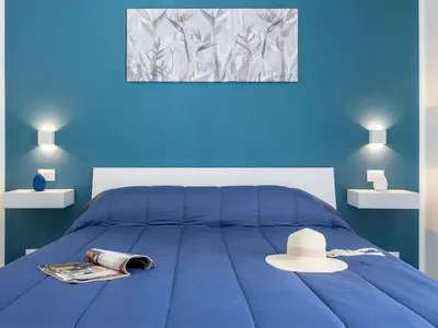 a blue bedroom with a bed with a hat on it at Apartment La Casetta di Clò by Interhome in Palermo