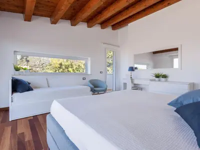 a white bedroom with a bed and a desk at Apartment Quirat Superior by Interhome in Terrasini