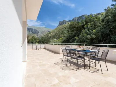 a patio with a table and chairs and mountains at Apartment Quirat Superior by Interhome in Terrasini