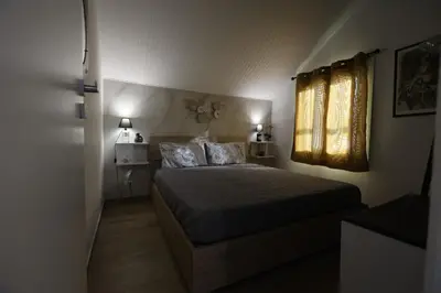a bedroom with a bed with two pillows and a window at Al Cottage Isola Delle Femmine in Isola delle Femmine
