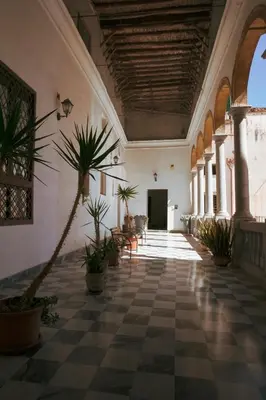 a hallway with potted plants in a building at B&B Palazzo Corvino in Palermo