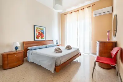 a bedroom with a bed and a large window at Casa Lov (Politeama) in Palermo