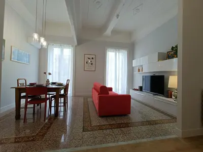 a living room with a red chair and a table at Casa Ranzano in Palermo