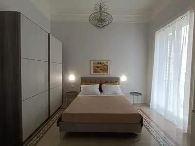 a bedroom with a bed and a chandelier at Casa Ranzano in Palermo