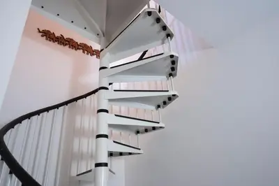 a spiral staircase in a house with white walls at Casa Sally con Vista Mare a Macari in Macari
