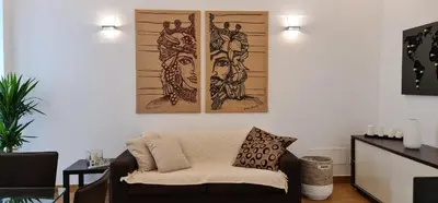 a living room with two pieces of art on the wall at Di Fresco Apartments Luxury Suites in Palermo